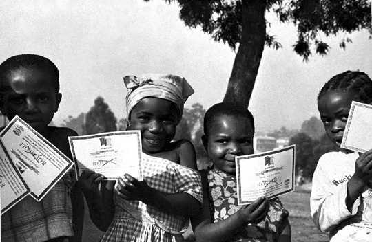Children in Cameroon show off their smallpox vaccination certificates in 1975.